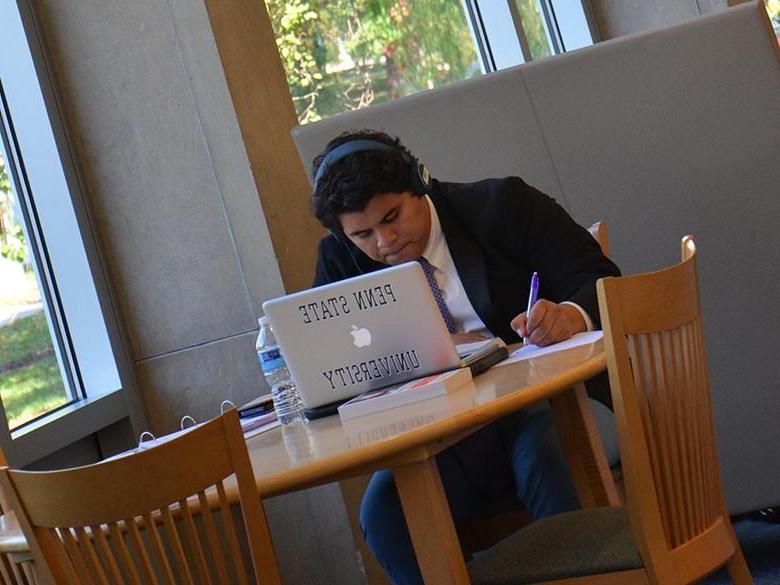 A student studying in the library using a laptop