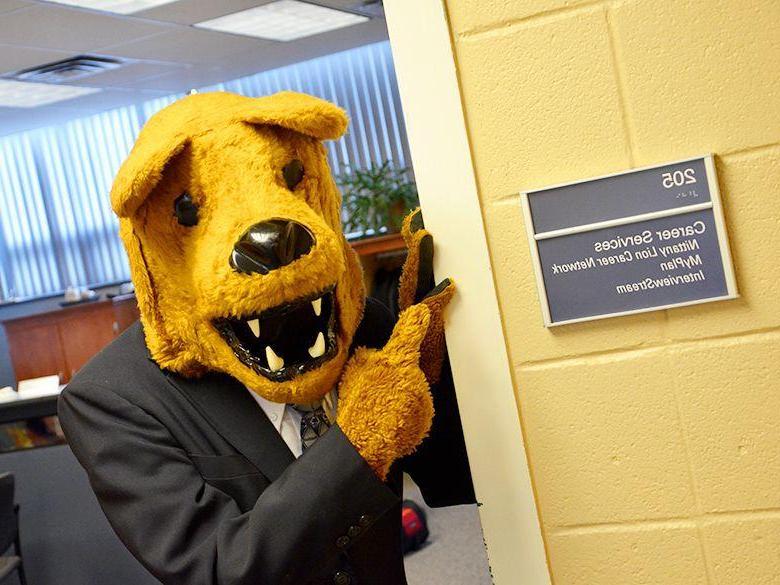 Nittany Lion in a suit pointing at 职业服务 office sign