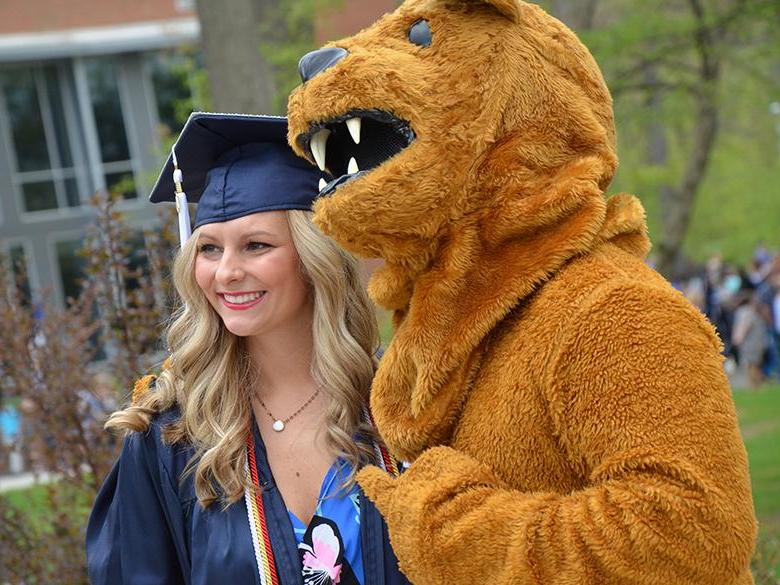 Nittany Lion mascot posing with recent graduate